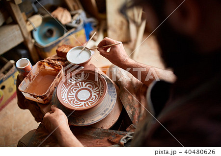 Scary face alike handmade potter mug on a wooden shelf, close-up, shellow depth of field. 40480626