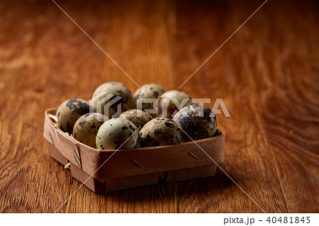 Quail eggs in a box on a rustic wooden background, top view, selective focus. Quail eggs in a box on a rustic wooden background, top view, selective focus. 40481845