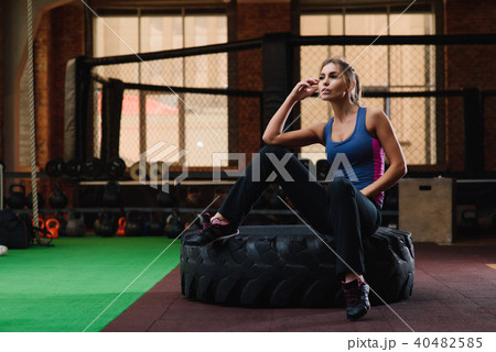 Girl sit at tire in gym Girl sit at tire in gym 40482585