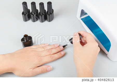 nail care. a woman covers her nails with transparent lacquer. 40482613