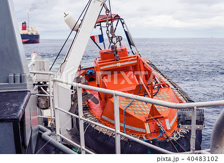 Lifeboat or FRC rescue boat in the vessel at sea. Tanker ship is on background Lifeboat or FRC rescue boat in the vessel at sea. Tanker ship is on background 40483102