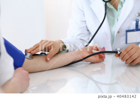 Doctor checking blood pressure of the patient, closeup. Cardiology in medicine and health car Doctor checking blood pressure of the patient, closeup. Cardiology in medicine and health car 40483142