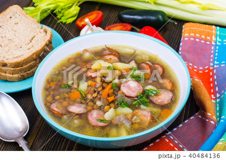 Soup with lentils, celery and sausages on old wooden table Soup with lentils, celery and sausages on old wooden table 40484136