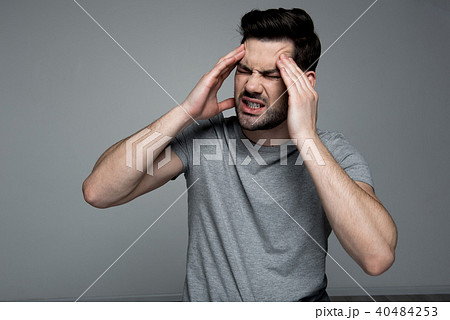 Youthful guy is having ache in his head Youthful guy is having ache in his head 40484253