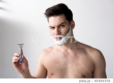 Serious guy is posing with foam on face Serious guy is posing with foam on face 40484359