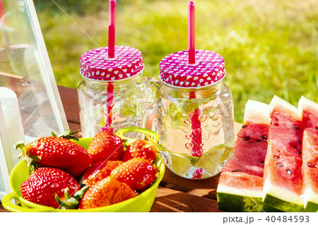 two glasses of lemonade and fruit on a picnic table 40484593