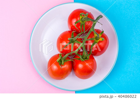 Branch of red tomatoes on bright background 40486022