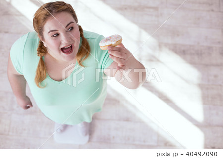 Happy stout woman trying donut 40492090