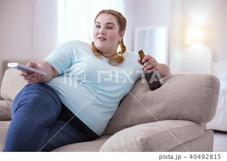 Obese young woman lying on the couch 40492815