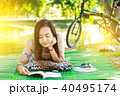 Asian woman  reading a book in the park. 40495174