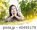 Asian woman smiling reading a book in the park. 40495178