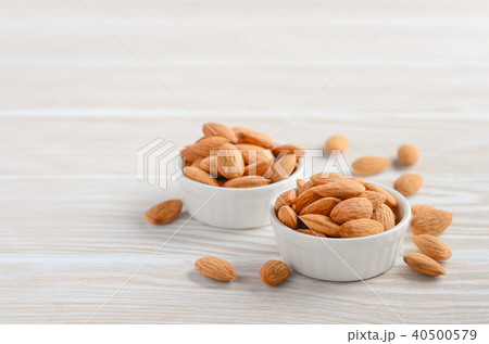 Almonds in a bowls on a white wooden background. Almonds in a bowls on a white wooden background. 40500579