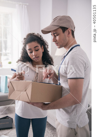 Pleasant good looking woman receiving the package 40501135