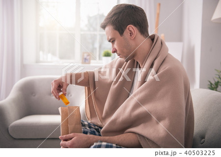 Serious young man taking out the medicine Serious young man taking out the medicine 40503225