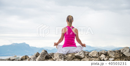 Woman meditating at the lake Woman meditating at the lake 40503231