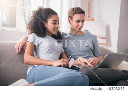 Joyful young couple sitting in front of the laptop Joyful young couple sitting in front of the laptop 40503235