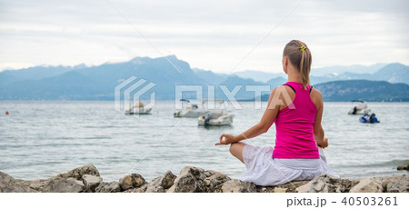 Woman meditating at the lake Woman meditating at the lake 40503261