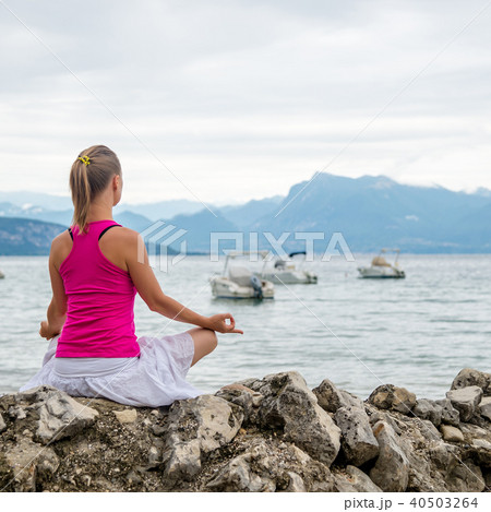Woman meditating at the lake 40503264