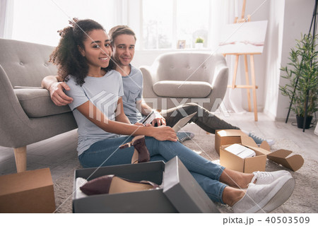 Nice positive couple doing online shopping together Nice positive couple doing online shopping together 40503509