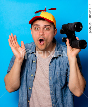 Young nerd man with noob hat using a binoculars 40505193