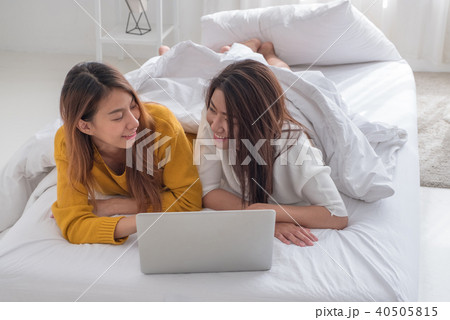 Asia lesbian lgbt couple lying on bed using laptop Asia lesbian lgbt couple lying on bed using laptop 40505815