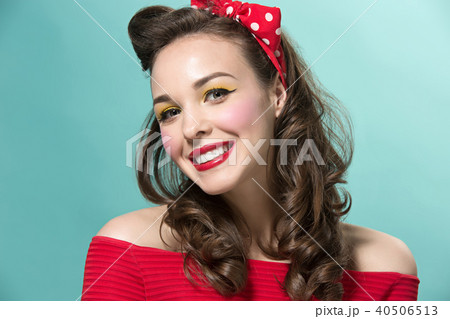 Beautiful young woman with pinup make-up and hairstyle. Studio shot on white background 40506513