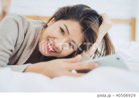 women are using smart phone on the bed in morning women are using smart phone on the bed in morning 40506929