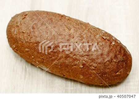 one black baked bread on a light wooden background one black baked bread on a light wooden background 40507047