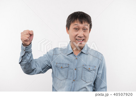 Pleasant delighted man holding his fist up Pleasant delighted man holding his fist up 40507920