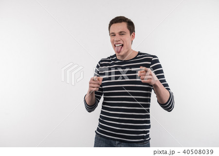Pleasant young man showing his tongue Pleasant young man showing his tongue 40508039