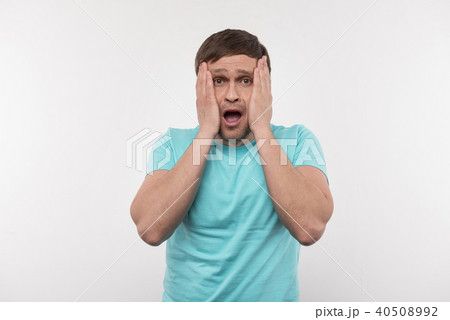 Scared young man touching his cheeks 40508992