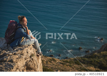 Woman speaking by phone on hill Woman speaking by phone on hill 40510921