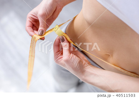 Close up of a centimeter tape around the waist 40511503
