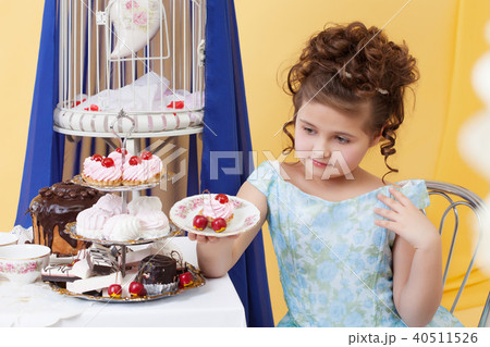 Elegant little girl posing with plate of sweets 40511526