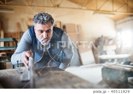 A man worker in the carpentry workshop, working with wood. 40511929
