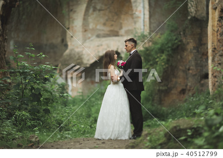 Beautiful fairytale newlywed couple hugging near old medieval castle 40512799