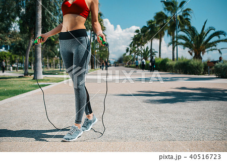 Sporty girl exercising on jumping-rope 40516723