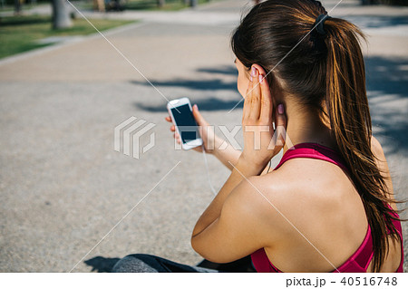 Calm young woman enjoying song from smartphone outdoor 40516748