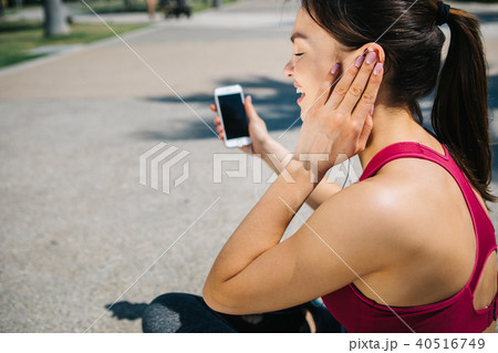 Excited female athlete listening to music after workout 40516749