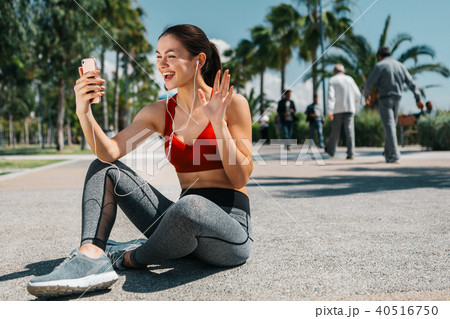 Excited female athlete using smartphone outside 40516750