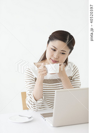 コーヒーを飲みながらパソコンを見る日本人女性 40520397