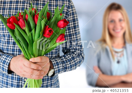 Picture of young man surprising woman with flowers 40521355