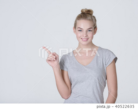 Smiling pretty woman pointing finger away Smiling pretty woman pointing finger away 40522635