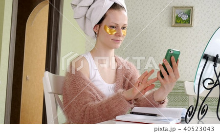 attractive business woman applying cosmetic facial spots at home, talking on the phone attractive business woman applying cosmetic facial spots at home, talking on the phone 40523043