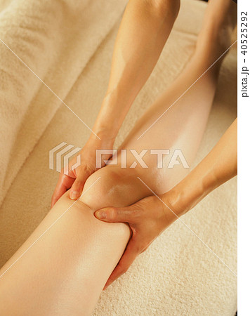 薄暗いエステサロンで膝のリンパを流す女性	 40525292