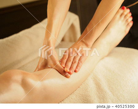 薄暗いエステサロンで膝のリンパを流す女性 薄暗いエステサロンで膝のリンパを流す女性 40525300