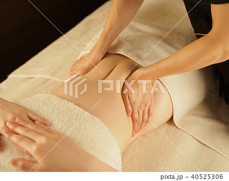 薄暗いエステサロンでお腹の脂肪を落とす女性	 40525306