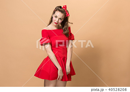 Beautiful young woman with pinup make-up and hairstyle. Studio shot on pastel background 40528208