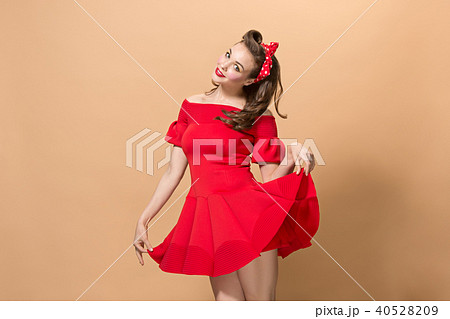 Beautiful young woman with pinup make-up and hairstyle. Studio shot on pastel background 40528209