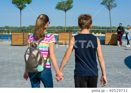 Teens holding hands rear view. Friendship 40529711